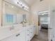 Bright bathroom with a large mirror, dual sink vanity, and an open doorway to the Primary bedroom at 6002 Sentinel Dr, Indian Trail, NC 28079