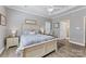 Well-lit bedroom with patterned bedding, tray ceilings, wood floors, and a ceiling fan at 6002 Sentinel Dr, Indian Trail, NC 28079