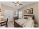 Cozy bedroom featuring a dark wood bed frame, neutral bedding, and an adjacent workspace at 6002 Sentinel Dr, Indian Trail, NC 28079