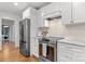 Bright kitchen featuring stainless steel appliances, white cabinets, and hardwood floors at 625 4Th Street Nw Dr, Hickory, NC 28601