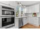 Kitchen featuring stainless steel appliances, white cabinets, marble counters, and hardwood floors at 625 4Th Street Nw Dr, Hickory, NC 28601