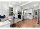 Open kitchen with stainless steel appliances, white cabinets, breakfast nook, and hardwood floors at 625 4Th Street Nw Dr, Hickory, NC 28601
