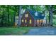 View of the rear of the home showing driveway, mature trees, and access to additional living space at 625 4Th Street Nw Dr, Hickory, NC 28601