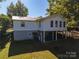 The back exterior of this raised home shows its pier and beam foundation and cozy backyard at 6312 Bill Ledford Rd, Vale, NC 28168