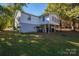 The back exterior of this raised home shows its pier and beam foundation and cozy backyard at 6312 Bill Ledford Rd, Vale, NC 28168