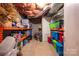 Unfinished basement with colorful plastic bins and shelving for storage at 6312 Bill Ledford Rd, Vale, NC 28168
