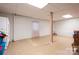 Unfinished basement space with tile flooring, support beam, and a small window at 6312 Bill Ledford Rd, Vale, NC 28168