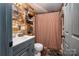 Bathroom featuring wood plank walls, sink, toilet and shower with decorative curtain at 6312 Bill Ledford Rd, Vale, NC 28168