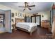 Bedroom with a wooden bed frame and ceiling fan with wooden floors and yellow walls at 6312 Bill Ledford Rd, Vale, NC 28168
