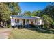Charming cottage-style home with a welcoming front porch, lush landscaping, and a metal roof at 6312 Bill Ledford Rd, Vale, NC 28168