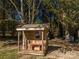 Backyard wooden playhouse with rustic details, sitting beneath mature trees and a hanging swing set at 6312 Bill Ledford Rd, Vale, NC 28168