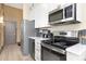 Kitchen with stainless steel appliances, modern white cabinets, and a large countertop with sink and fixtures at 715 N Church St # 816, Charlotte, NC 28202