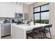 Modern kitchen featuring stainless steel appliances, white cabinetry, an island with seating, and a scenic window view at 715 N Church St # 816, Charlotte, NC 28202
