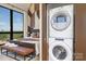 Convenient in-unit laundry featuring a stacked washer and dryer, next to bedroom at 715 N Church St # 816, Charlotte, NC 28202