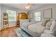 Sunlit bedroom featuring a queen size bed, two windows, and hardwood floors at 7300 Chatterbird Ct, Charlotte, NC 28226