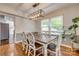 Cozy dining area with a dark wood table, white chairs, and an attractive pendant light fixture at 7300 Chatterbird Ct, Charlotte, NC 28226