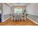 Sunlit dining room with a rustic wood table, white chairs, and modern lighting fixture at 7300 Chatterbird Ct, Charlotte, NC 28226