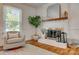 Cozy living area with a white brick fireplace, wood mantle, and a neutral color scheme at 7300 Chatterbird Ct, Charlotte, NC 28226