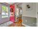 Inviting foyer featuring a red door, wood floors, and a glimpse into the living area at 7300 Chatterbird Ct, Charlotte, NC 28226