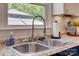 Close-up of a stainless steel sink with a gooseneck faucet, complemented by a bright window view at 7300 Chatterbird Ct, Charlotte, NC 28226