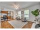 Spacious living room with wood floors, large windows, a ceiling fan, and a built-in desk at 7300 Chatterbird Ct, Charlotte, NC 28226