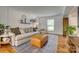 Bright living room featuring a neutral sofa, leather ottoman, and stylish decor against white paneled walls at 7300 Chatterbird Ct, Charlotte, NC 28226
