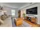 Cozy living space with a large TV, wood floors, stylish furniture, and natural light at 7300 Chatterbird Ct, Charlotte, NC 28226
