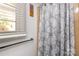 Bathroom detail highlighting a window with blinds and a stylish shower curtain with floral patterns at 846 Gist Rd, Rock Hill, SC 29732