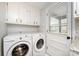 Laundry room featuring a full-size washer and dryer, storage cabinets, and a door at 846 Gist Rd, Rock Hill, SC 29732