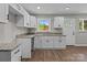 Well-lit kitchen featuring white cabinets, granite countertops, and a stainless steel sink at 880 Legion Club Rd, Salisbury, NC 28146