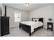 Bedroom with a black bed frame, carpeted floors, and minimalist decor at 9102 Buckley Ct, Charlotte, NC 28269