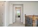 Upstairs hallway with a view into a bedroom, featuring a decorative wooden railing at 9102 Buckley Ct, Charlotte, NC 28269