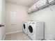 Laundry room featuring white washer and dryer, tile flooring, and storage at 9102 Buckley Ct, Charlotte, NC 28269