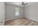 Bright, empty bedroom showcasing a ceiling fan, light-colored walls, and wood-look flooring at 104 Cleveland Ave, Albemarle, NC 28001