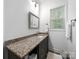 Modern bathroom features a granite countertop, a framed mirror, and a towel rack, with bright natural light at 11104 Pine Grove Ave, Mint Hill, NC 28227