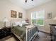 Cozy bedroom featuring a white metal bed frame, dark hardwood floors, and a bright window at 11104 Pine Grove Ave, Mint Hill, NC 28227