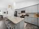 Modern kitchen features gray cabinets, granite countertops, stainless steel appliances, and a spacious island with seating at 11104 Pine Grove Ave, Mint Hill, NC 28227