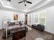 Well-lit main bedroom features a tray ceiling, a full bed, a sitting area, and modern décor at 11104 Pine Grove Ave, Mint Hill, NC 28227