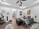 Comfortable main bedroom featuring a tray ceiling, a sitting area, and access to the ensuite bathroom at 11104 Pine Grove Ave, Mint Hill, NC 28227