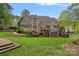 Expansive backyard with lush green lawn, landscaped garden beds, a spacious deck, and mature trees at 116 Anderson Farm Ct, Mooresville, NC 28117