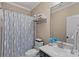 Cozy bathroom with blue accents, featuring a shower with a blue patterned curtain and blue flowers on the vanity at 116 Anderson Farm Ct, Mooresville, NC 28117