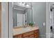 Well-lit bathroom with a wood vanity, large mirror, and neutral wall color at 116 Anderson Farm Ct, Mooresville, NC 28117