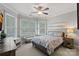 Serene bedroom featuring a ceiling fan, bay window, and a comfortable bed with blue floral bedding at 116 Anderson Farm Ct, Mooresville, NC 28117
