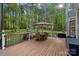 Outdoor deck with a dining table, chairs, an umbrella, and scenic views of the backyard and play area at 116 Anderson Farm Ct, Mooresville, NC 28117