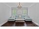 Elegant living room with dark hardwood floors, a blue sectional sofa, and a stylish chandelier at 116 Anderson Farm Ct, Mooresville, NC 28117