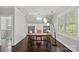 Bright home office with large windows, built-in shelving, and a wooden desk illuminated by a modern chandelier at 116 Anderson Farm Ct, Mooresville, NC 28117