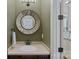 Charming powder room featuring a decorative mirror and elegant fixtures at 116 Anderson Farm Ct, Mooresville, NC 28117