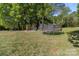 Playground set, trampoline, and a dog kennel in a large grassy backyard at 1238 Moss Springs Rd, Albemarle, NC 28001