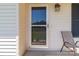 Close-up of front door with storm door, chair and exterior lantern at 1238 Moss Springs Rd, Albemarle, NC 28001