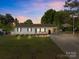 Charming single-story home featuring manicured lawn, carport, and inviting front porch with cozy bench seating at 1238 Moss Springs Rd, Albemarle, NC 28001